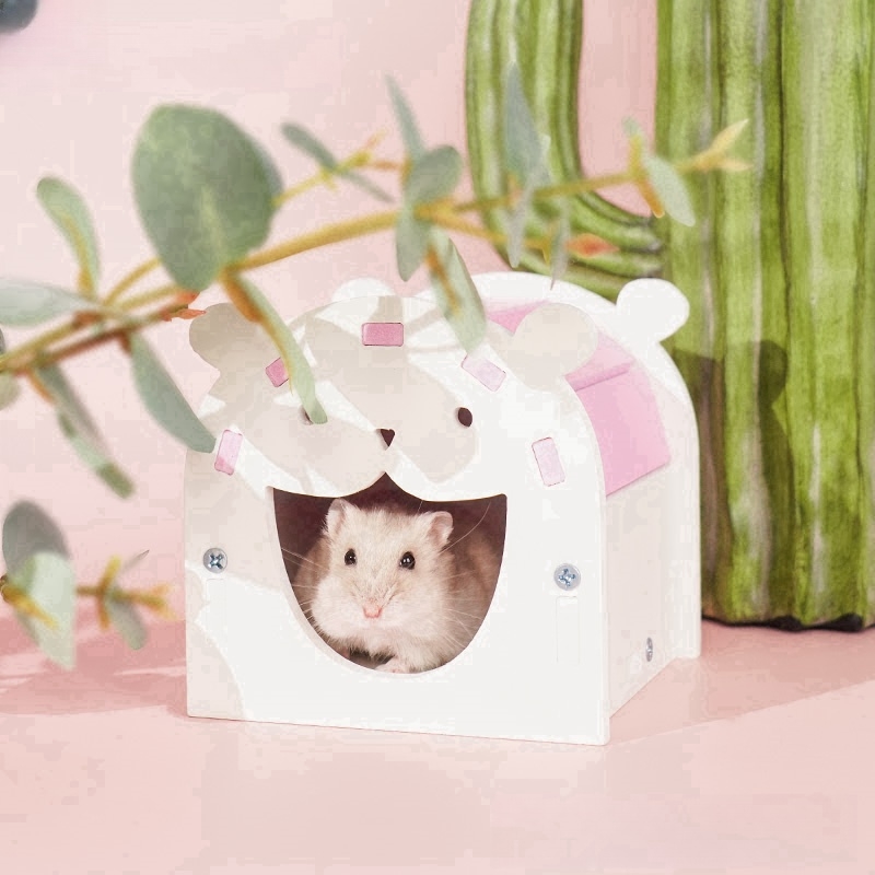 hamster inside a pink and white wooden cage